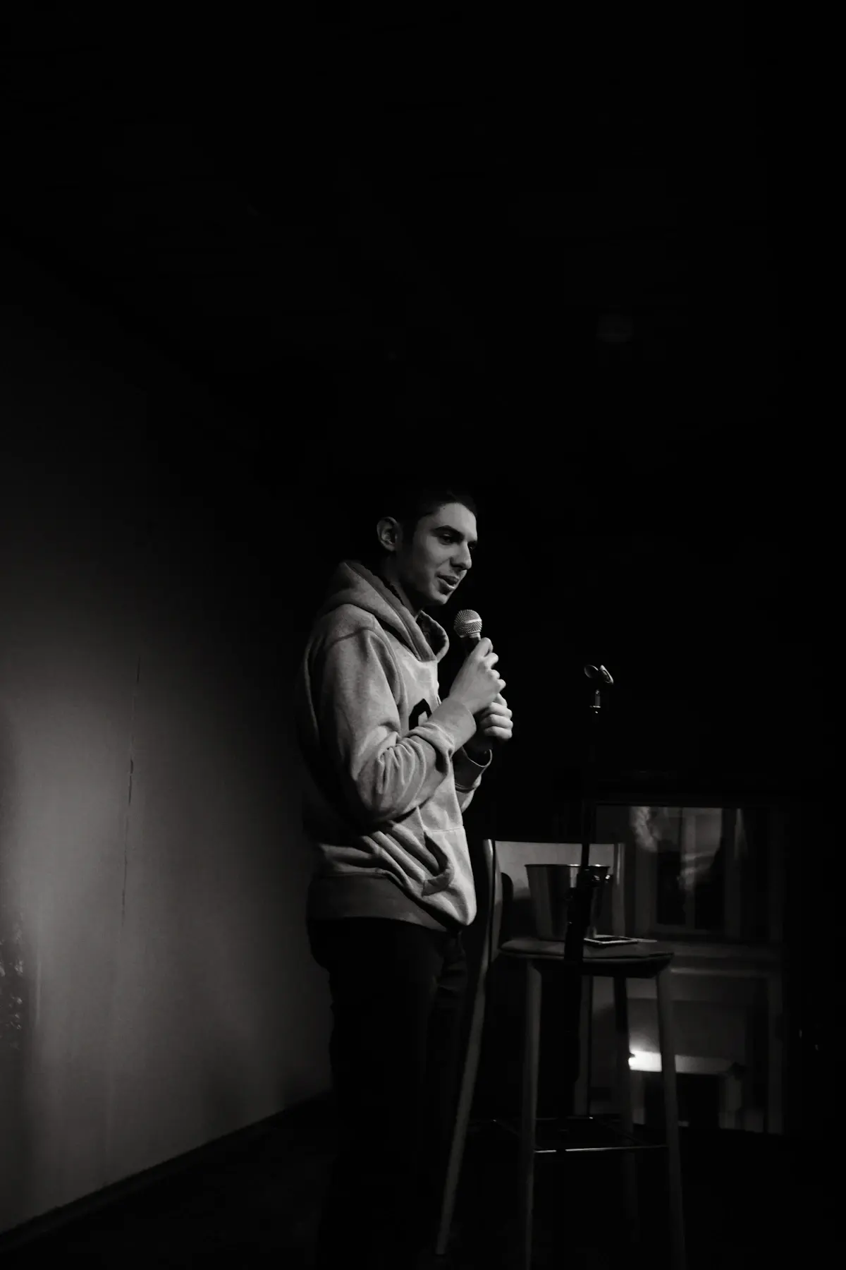 A performer holding a microphone in a dark club room