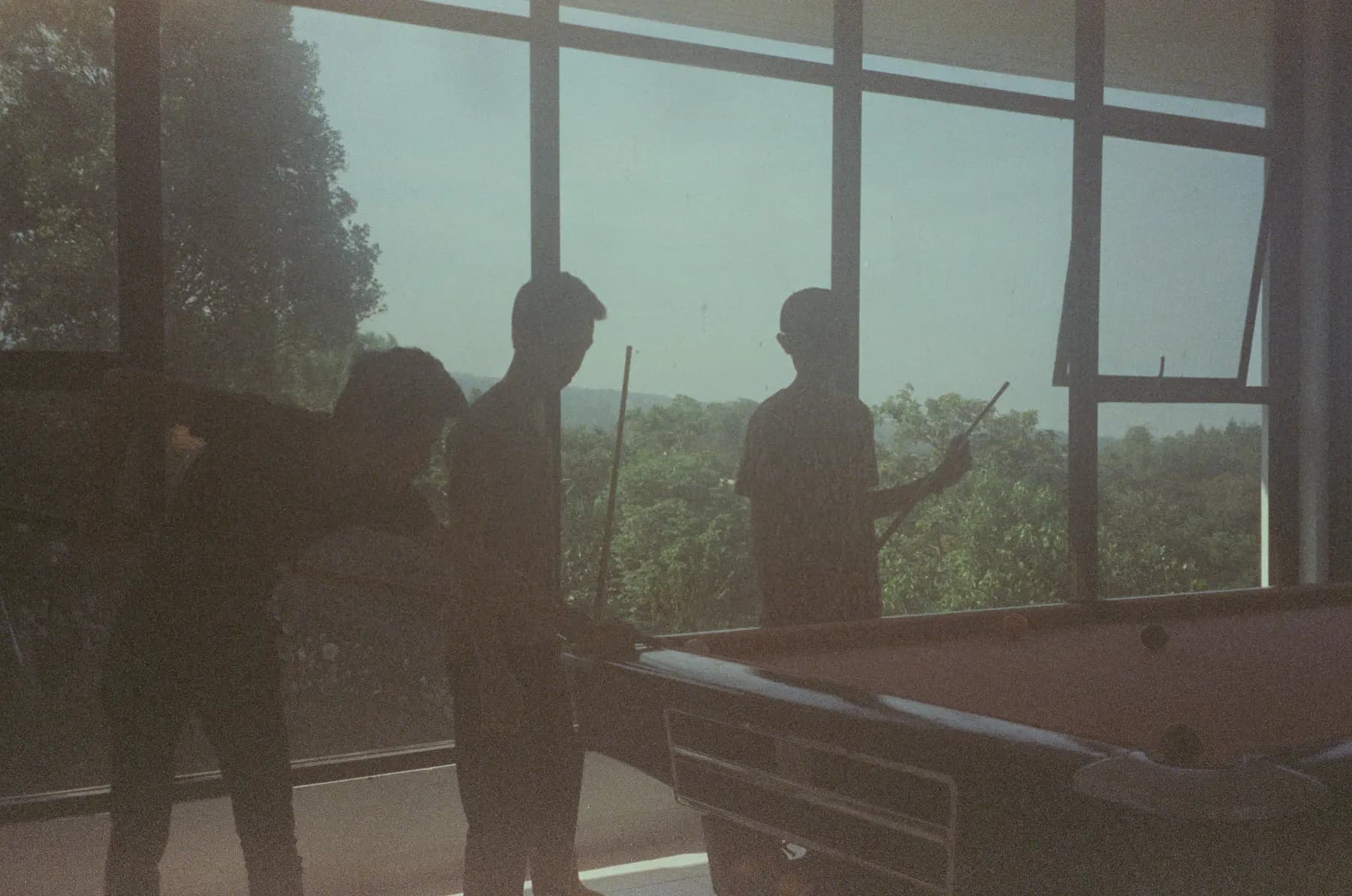 Friends gathered around a pool table