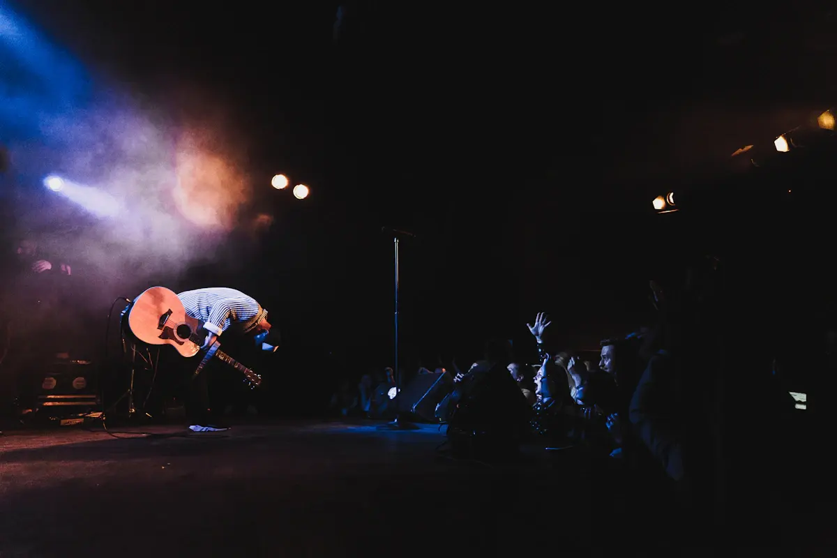 A guitarist performing on stage under concert lights