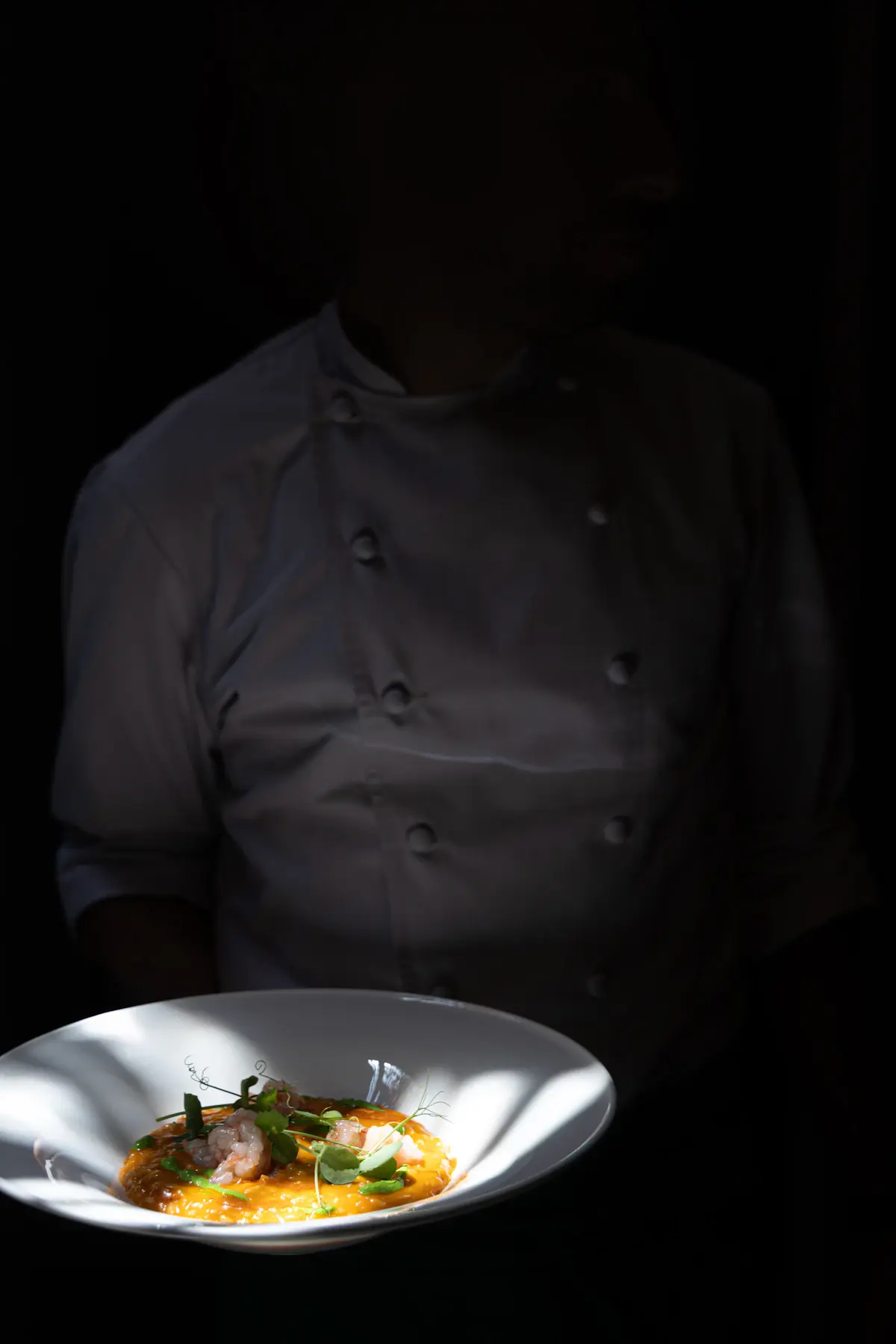 A chef serving a finished dish between activities